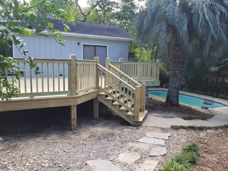 Poolside deck with railing and stairs