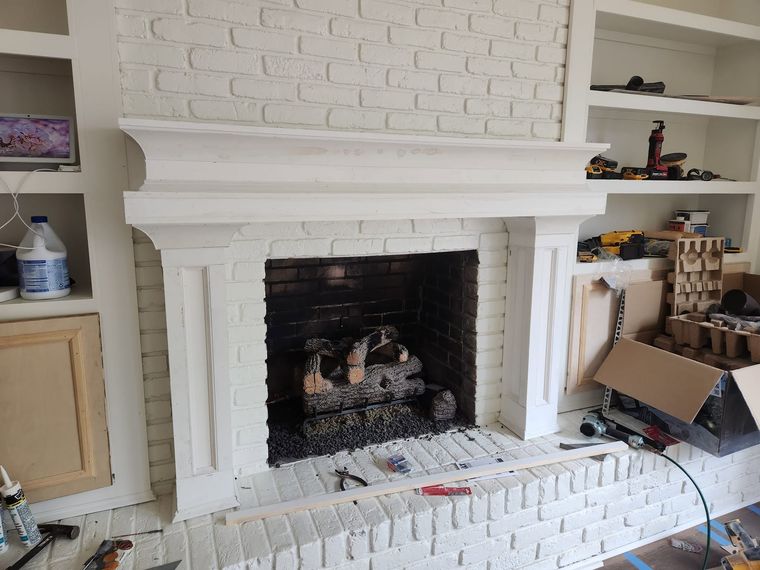 White painted brick fireplace with custom built-in shelving